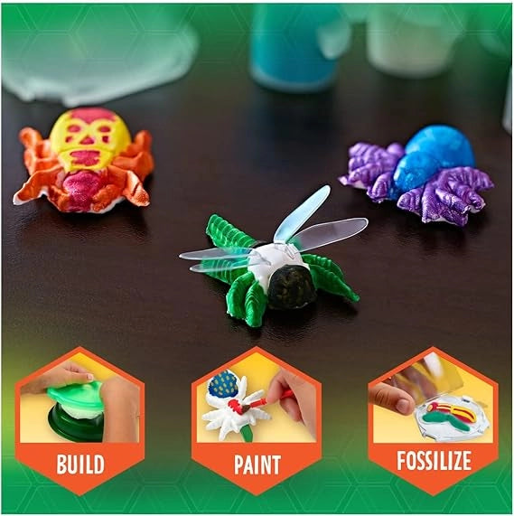 Colorful toy figures on a dark surface with 'Build', 'Paint', and 'Fossilize' stages displayed.