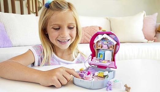 A kid is playing with polly pocket set.