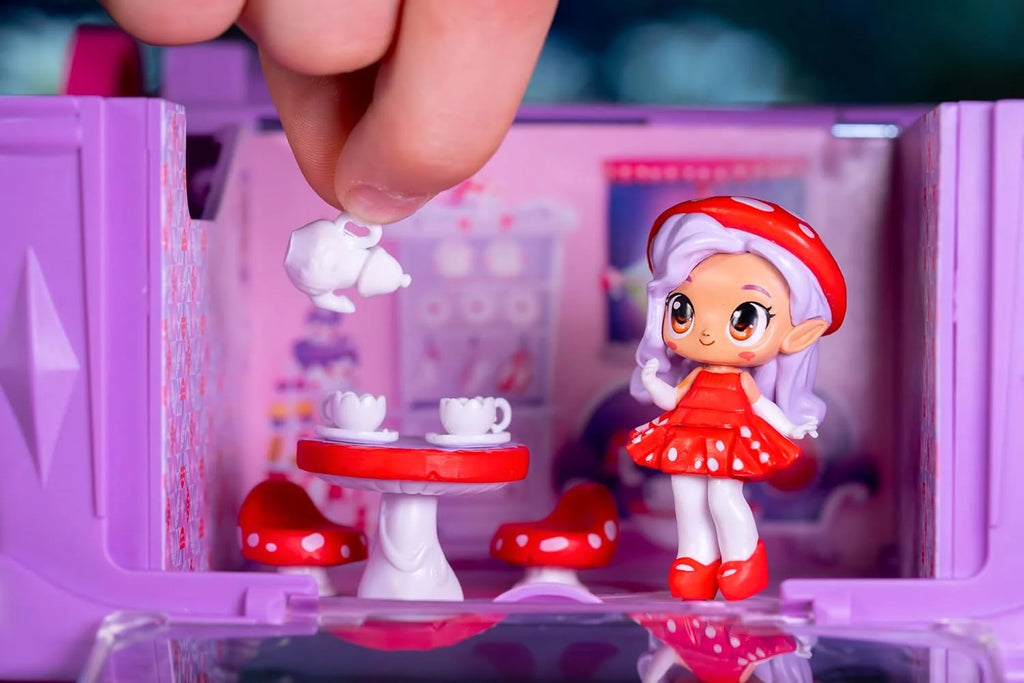 A hand holding a teapot accessory with doll figure  