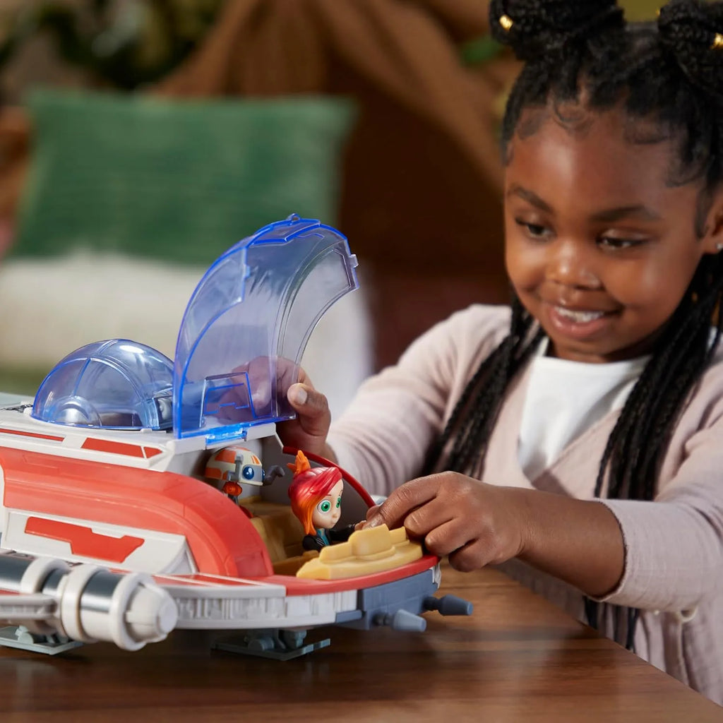 Child playing with a toy vehicle on a wooden table