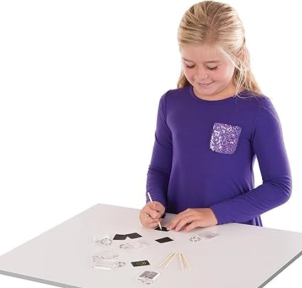 A girl is scratching MELISSA & DOUG KEY CHAIN SCRATCH ART PARTY PACK
