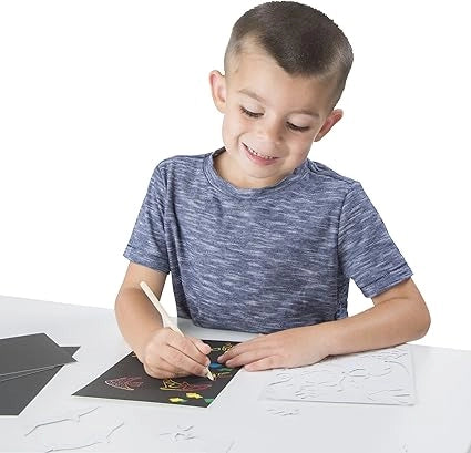 The boy is scratching sea life sheets with scratch pen