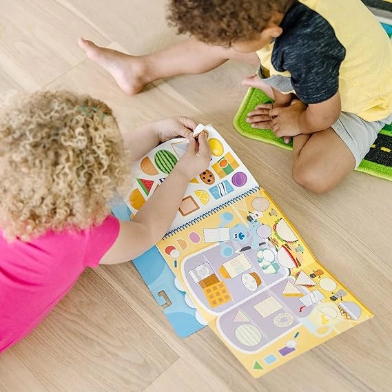 Two children playing with educational mats on a wooden floor.