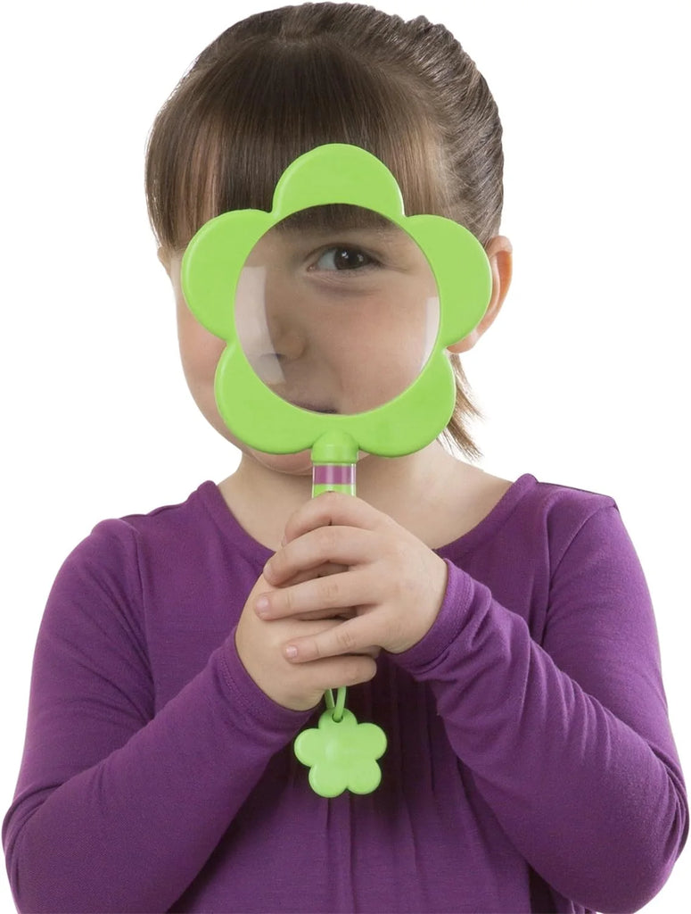 Girl is looking through magnifying glass