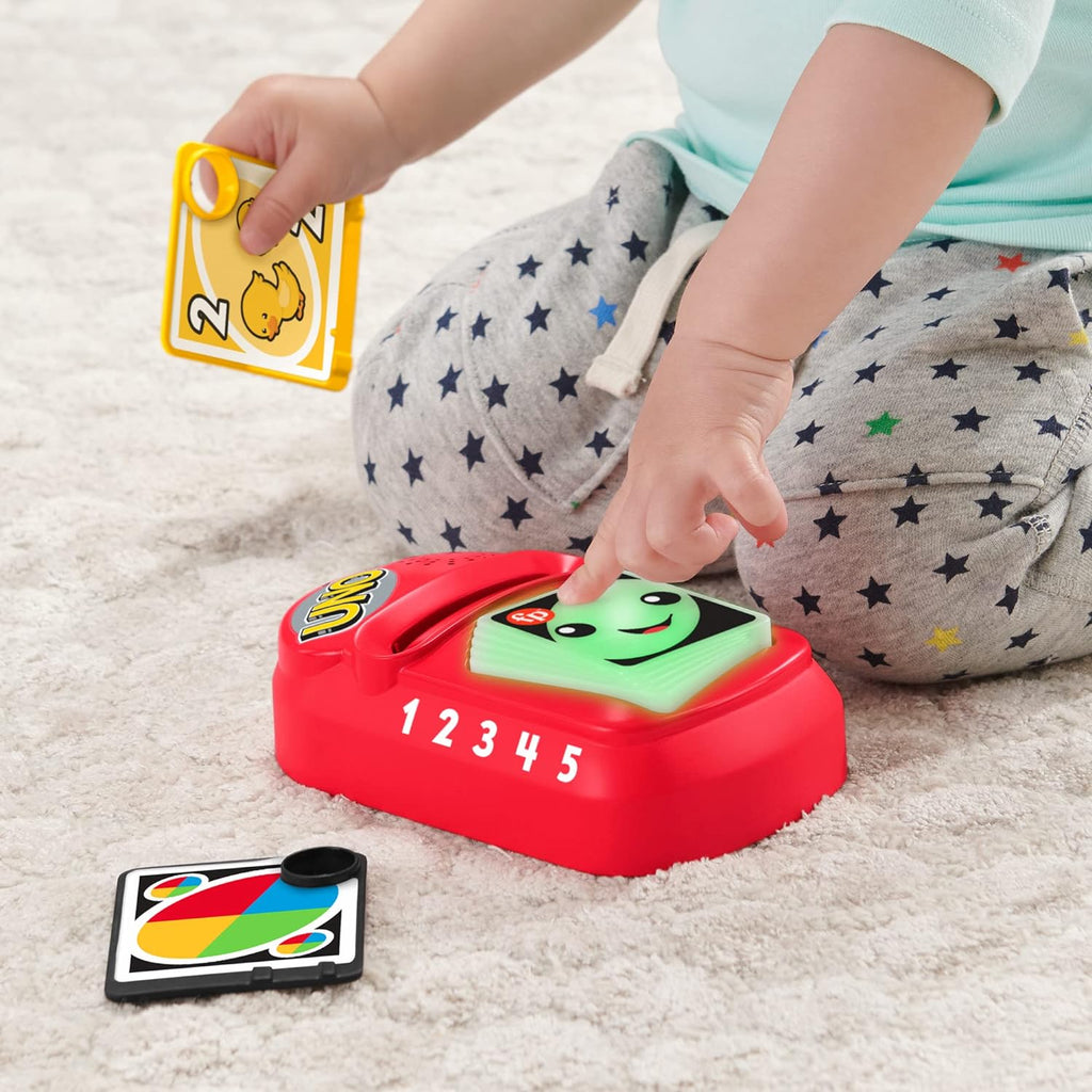 A kid is pressing button of counting color uno toy