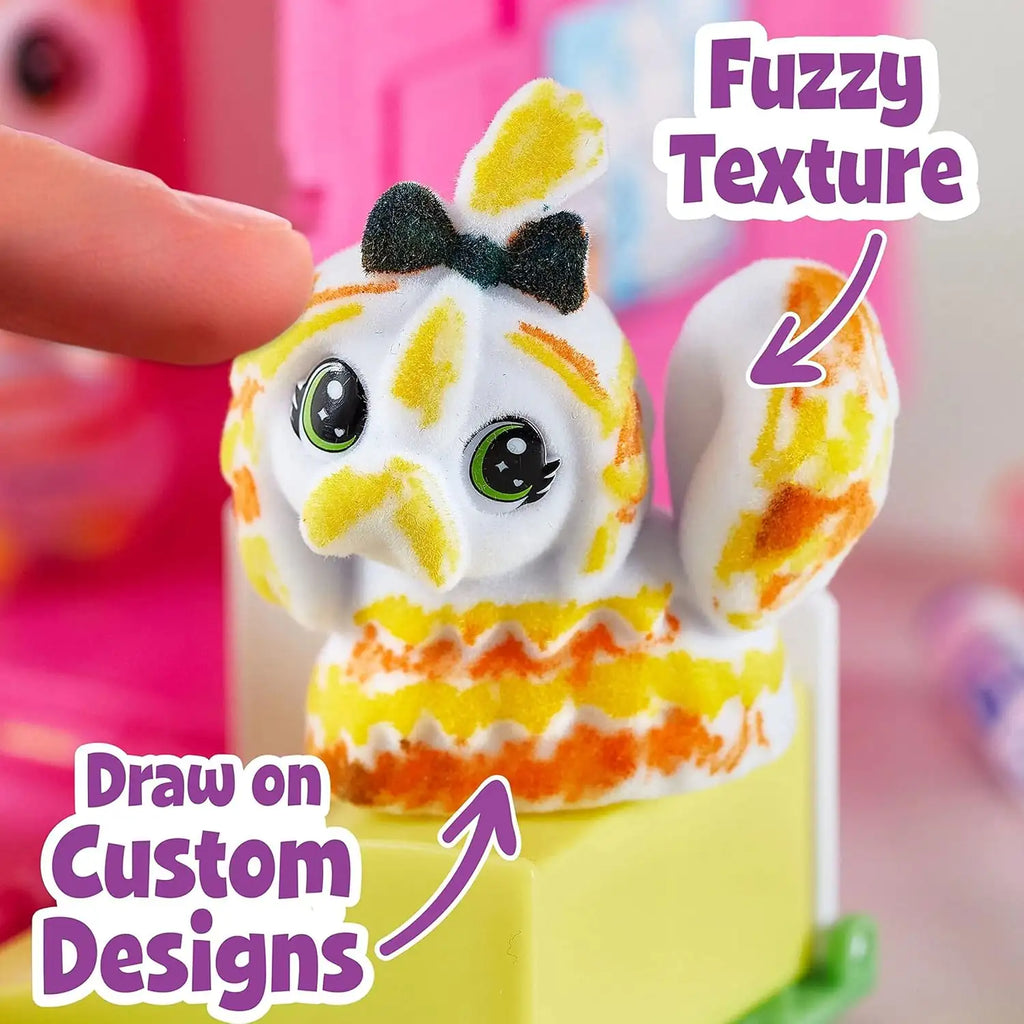 Toy figure with fuzzy texture and customizable designs, held by a hand.