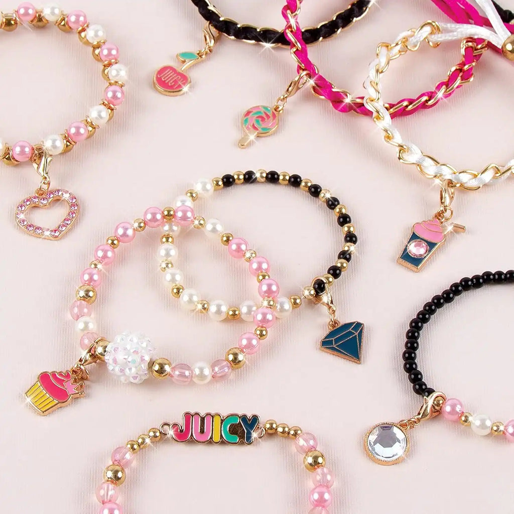Collection of colorful bracelets with charms on a light pink background