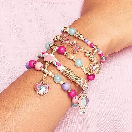 Colorful beaded bracelets with charms on a wrist against a pink background